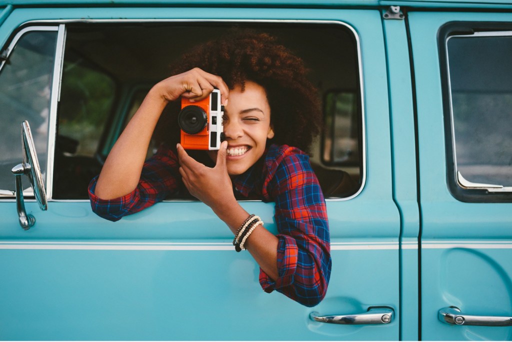 Person in turquoise truck taking photos